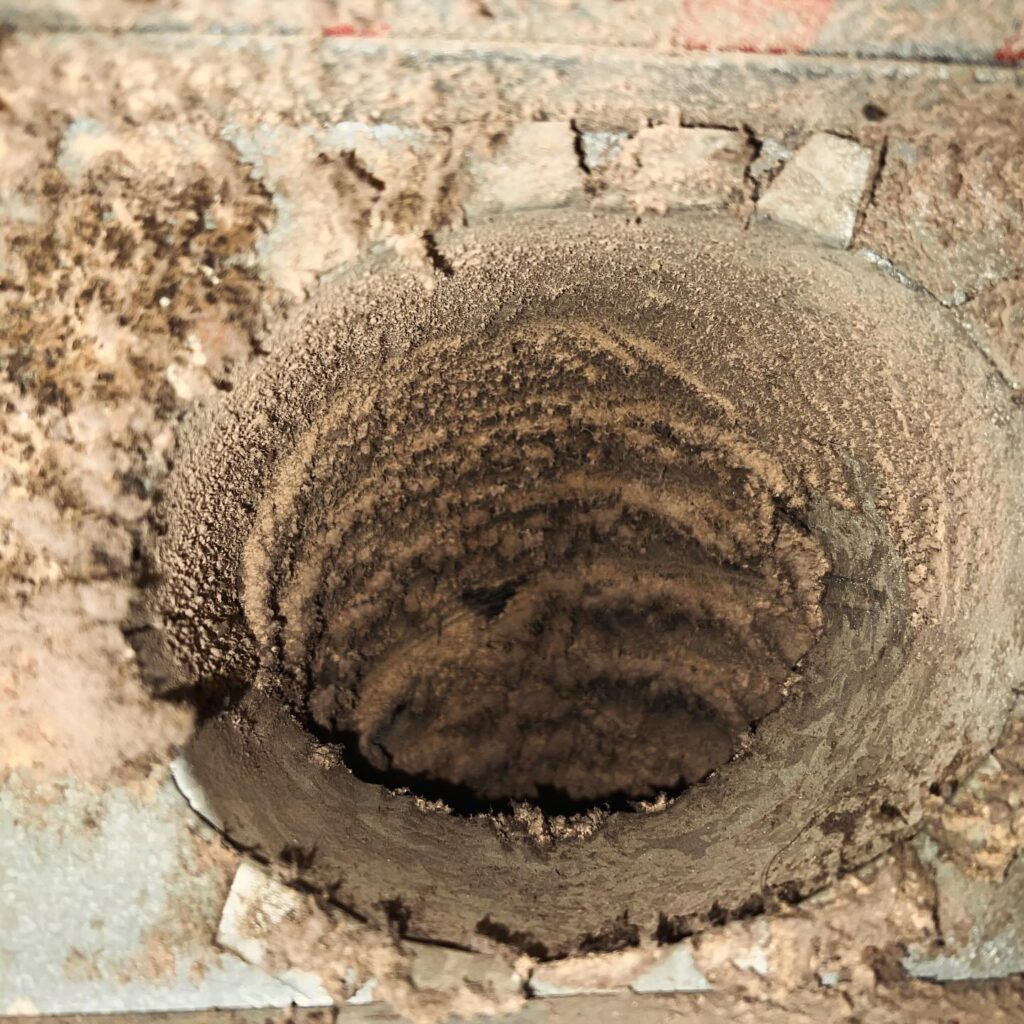 Clogged dryer vent packed with heavy lint buildup