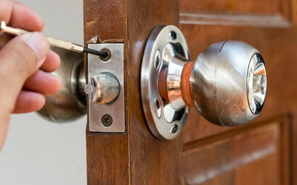 A locksmith expertly repairing or unlocking a door lock.
